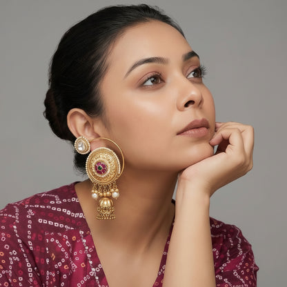 Woman wearing gold earrings with a neutral background