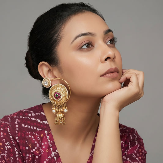 Woman wearing gold earrings with a neutral background